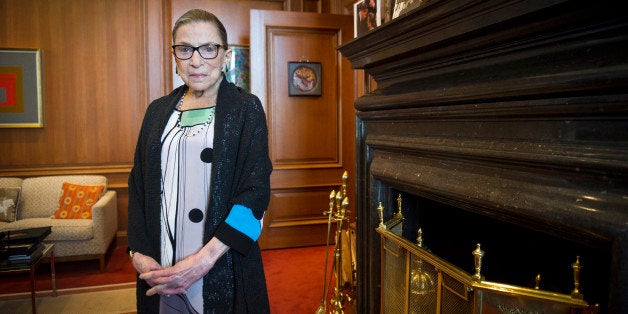 FILE - In this July 31, 2014 file photo, Supreme Court Justice Ruth Bader Ginsburg stands in her Supreme Court chambers in Washington. Ginsburg is questioning lawyers in Supreme Court arguments in her usual exacting fashion, five days after she had a stent implanted to clear a blocked artery. The 81-year-old Ginsburg was actively participating in the give-and-take of the court's session Monday. (AP Photo/Cliff Owen, File)