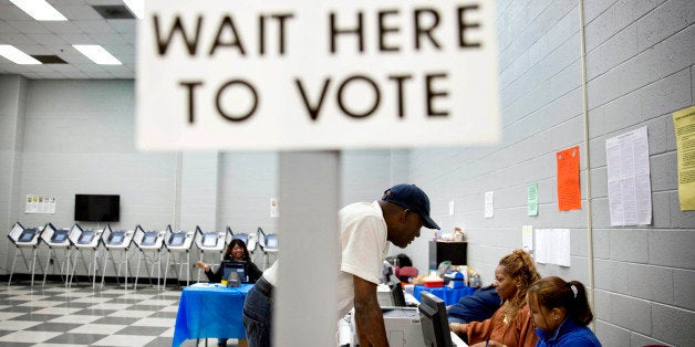 In this May 16, 2014 photo, Charles Poole, 70, checks in upon arriving to cast his ballot at a polling site during early voti