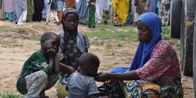 A woman and her children who fled their home following an attack by Islamist militants in Bama and other parts, take refuge a