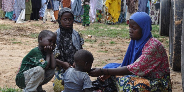 A woman and her children who fled their home following an attack by Islamist militants in Bama and other parts, take refuge at a school in Maiduguri, Nigeria, Tuesday, Sept. 9, 2014. Fleeing residents say Boko Haram fighters are patrolling 50 kilometers (32 miles) of the main road between two of several towns the Islamic extremists have seized in a 200-mile (320-kilometer) arc running alongside northeast Nigeria's border with Cameroon. (AP Photo/Jossy Ola)