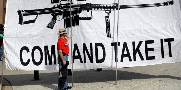 A demonstrator helps hold a large "Come and Take It" banner at a rally in support of open carry gun laws at the Capitol, Monday, Jan. 26, 2015, in Austin, Texas. (AP Photo/Eric Gay)