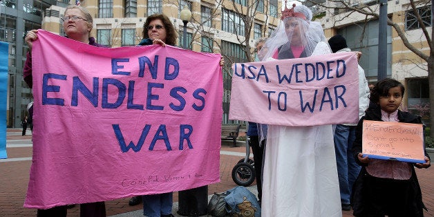 OAKLAND, CA - FEBRUARY 17: Demonstrators hold signs during a news conference in front of the Oakland Federal Building to speak out against a proposed military campaign against ISIS on February 17, 2015 in Oakland, California. Over a dozen peace activists staged a news conference in front of the Oakland Federal Building to oppose U.S. president Barack Obama's request for a new authorization to use military force to battle the radical terrorist group ISIS. (Photo by Justin Sullivan/Getty Images)