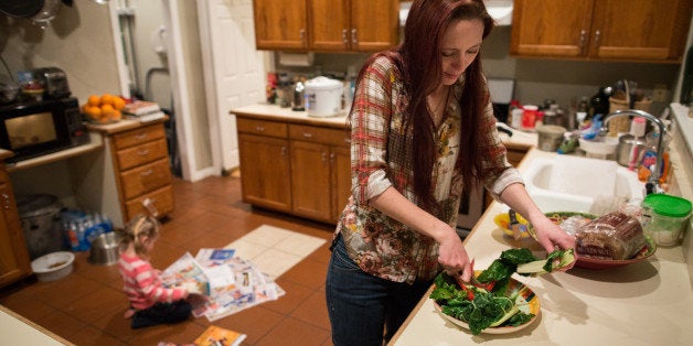 Maggie Barcellano prepares dinner at her father's house in Austin, Texas on Saturday, Jan. 25, 2014. Barcellano, who lives with her father, enrolled in the food stamps program to help save up for paramedic training while she works as a home health aide and raises her three-year-old daughter. Working-age people now make up the majority in U.S. households that rely on food stamps, a switch from a few years ago when children and the elderly were the main recipients. (AP Photo/Tamir Kalifa)