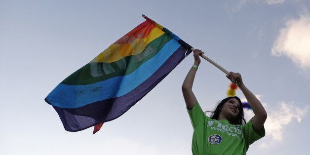 An Israeli young woman waving the rainbow LGTB flag during the Gay Pride Parade in Jerusalem Israel on 18 September 2014. 