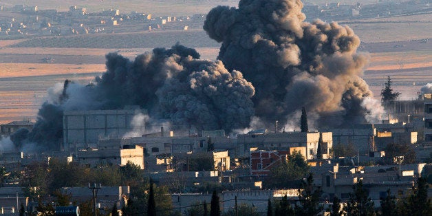 A bombs, seen top left, falls on an Islamic State position in eastern Kobani, during an airstrike by the US led coalition, seen from a hilltop outside Suruc, on the Turkey-Syria border Saturday, Nov. 8, 2014. Kobani, also known as Ayn Arab, and its surrounding areas, has been under assault by extremists of the Islamic State group since mid-September and is being defended by Kurdish fighters. (AP Photo/Vadim Ghirda)