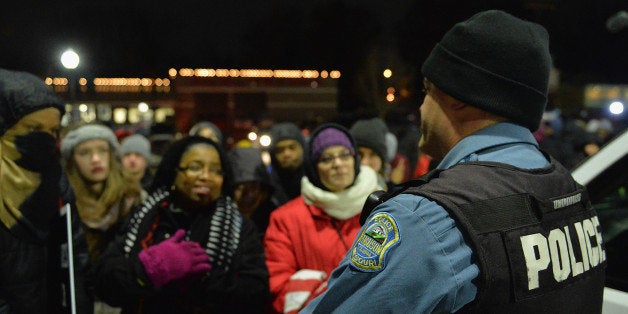 FERGUSON, MO - MARCH 4: A Ferguson police officer listens to the concerns of a protestor as they demonstrate outside the Ferguson Police Department in Ferguson, Missouri on March 4, 2015. The Federal Department of Justice decided today not to charge then Ferguson Police Officer, Darren Wilson, of any wrongdoing in the August shooting of Michael Brown Jr. The Department of Justice investigation did happen to find Ferguson Police Departments involvement in racially based policing. (Photo by Michael Thomas/Getty Images)