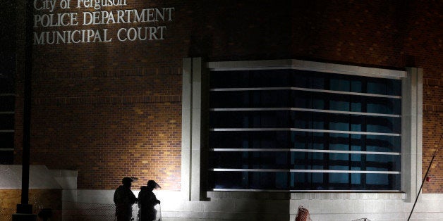 FILE - In this Nov. 26, 2014, file photo, nembers of Missouri National Guard stand outside of the Ferguson Police Department and the Municipal Court in Ferguson, Mo. A Justice Department investigation has found patterns of racial bias in the Ferguson police department and at the municipal jail and court. The full report, to be publicly released on March 4, says the investigation found Ferguson officers disproportionately used excessive force against blacks and too often charged them with petty offenses. (AP Photo/Jeff Roberson, File)