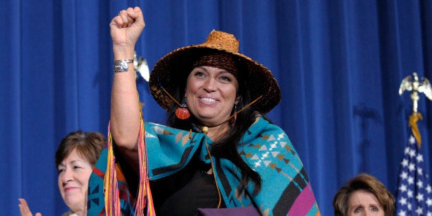 Deborah Parker, vice chairwoman of the Tulalip Tribes of Washington State, center, flanked by Sen. Susan Collins, R-Maine, left, and House Minority Leader Nancy Pelosi of Calif., gestures before President Barack Obama before he signed the Violence Against Women Act, Thursday, March 7, 2013, at the Interior Department in Washington. (AP Photo/Susan Walsh)