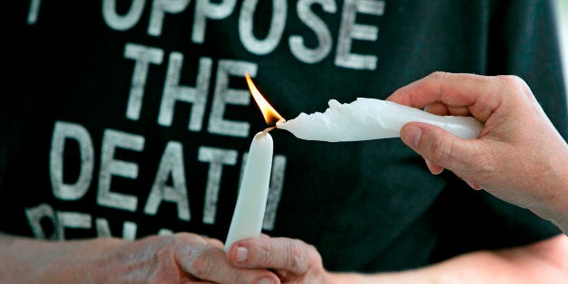 Anti-death penalty advocates light each other's candles during a prayer service for the souls of death row inmate Dale Leo Bishop, who was executed Wednesday, July 23, 2008, and the victim, Marcus James Gentry at the Mississippi State Penitentiary in Parchman, Miss. (AP Photo/Rogelio V. Solis)