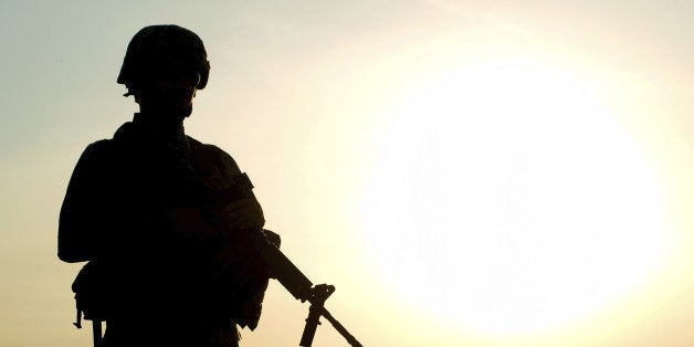 Silhouette of US soldier with rifle against a sunset