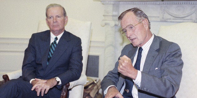 U.S. President George H. Bush drives home his point while he and Secretary of State James A. Baker III talks with reporters d