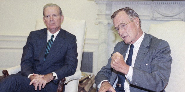 U.S. President George H. Bush drives home his point while he and Secretary of State James A. Baker III talks with reporters during a short Oval Office photo session, Friday, Sept. 6, 1991 in Washington. The President announced that in order to "give peace a chance" he will ask Congress for a four-month delay on Israel's request for $10 billion in loan guarantees for refugee housing. (AP Photo/Greg Gibson)