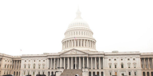 UNITED STATES - Jan 15: A cyclist makes his way across the East Front plaza of the U.S. Capitol as heavy fog covers the dome