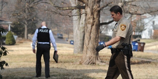 Police officials conduct an investigation in the Ferguson, Missouri neighborhood near the area of the overnight shooting of t