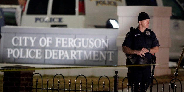 Police stand watch outside the Ferguson Police Department where two police officers were shot Thursday, March 12, 2015, in Ferguson, Mo. (AP Photo/Jeff Roberson)