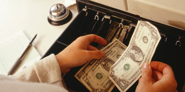 Woman taking payment at fast food restaurant, close up of cash register