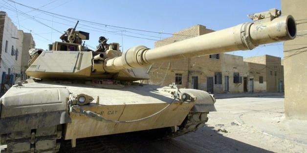 NAJAF, IRAQ: A US tank takes position in Najaf's al-Jadida al-Talat area, 200m south of the shrine of Imam Ali, 19 August 2004 during clashes with militiamen loyal to radical Shiite Muslim cleric Moqtada Sadr. US forces are engaged in intensive battle with militiamen as they move in on the shrine. The Iraqi government said an offensive against Shiite rebels in Najaf would be launched within hours unless Sadr publicly disarms, after charging him with trickery. 'The Iraqi government has laid down conditions that Moqtada Sadr must promise in a press conference not to resort to violence in the future and that the Mehdi Army is to be dissolved,' Minister of State Kassem Daoud said. AFP PHOTO/Saeed KHAN (Photo credit should read SAEED KHAN/AFP/Getty Images)