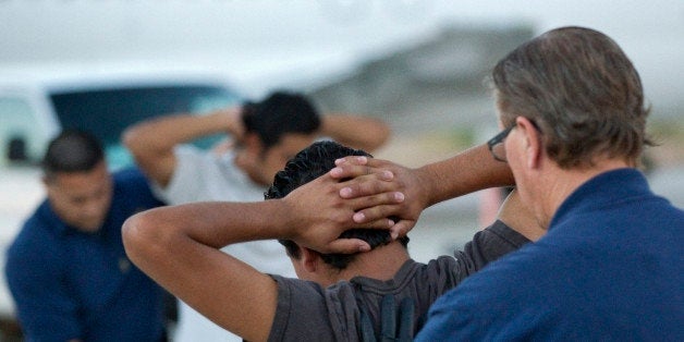 Illegal immigrants from El Salvador are searched prior to boarding an MD-80 aircraft for a repatriation flight of 80 illegal immigrants back to their home country, Tuesday, June 26, 2012 at Phoenix-Mesa Gateway Airport in Mesa, Ariz. Immigration and Customs Enforcement (ICE) operate four to five repatriation flights weekly out of Mesa to El Salvador, Guatemala and Honduras. Shackled violent offenders, minors and women are separated on the flight and are turned over to El Salvador's immigration officers upon arrival. (AP Photo/Matt York)