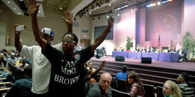 FILE - In this Sept. 9, 2014 file photo, Marurice Brown raises his arms during a public comments portion of a meeting of the Ferguson City Council, back right, in Ferguson, Mo. Candidates for the first municipal election in Ferguson since a fatal police shooting brought the St. Louis suburb international notoriety face a filing deadline Tuesday, Jan. 20, 2015. Ferguson is nearly 70 percent black, all but one of its elected leaders is white. (AP Photo/Jeff Roberson, File)