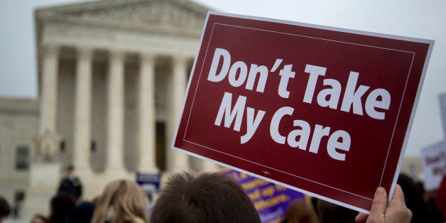 Demonstrator Elodie Huttner holds a sign in support of U.S. President Barack Obama's health-care law, Obamacare, in front of the U.S. Supreme Court in Washington, D.C., U.S., on Wednesday, March 4, 2015. A U.S. Supreme Court argument over Obamacare's tax subsidies divided the justices along ideological lines, potentially leaving two pivotal justices to decide the law's fate. Photographer: Andrew Harrer/Bloomberg via Getty Images