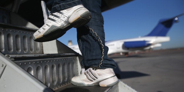 MESA, AZ - FEBRUARY 28: A Honduran immigration detainee, his feet shackled and shoes laceless as a security precaution, boards a deportation flight to San Pedro Sula, Honduras on February 28, 2013 in Mesa, Arizona. U.S. Immigration and Customs Enforcement (ICE), operates 4-5 flights per week from Mesa to Central America, deporting hundreds of undocumented immigrants detained in western states of the U.S. With the possibility of federal budget sequestration, Most detainees typically remain in custody for several weeks before they are deported to their home country, while others remain for longer periods while their immigration cases work through the courts. (Photo by John Moore/Getty Images)