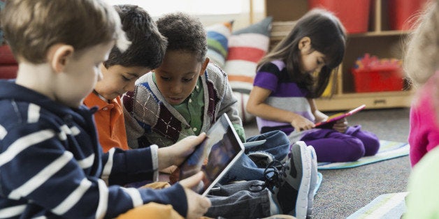 Boys using digital tablet together in elementary school