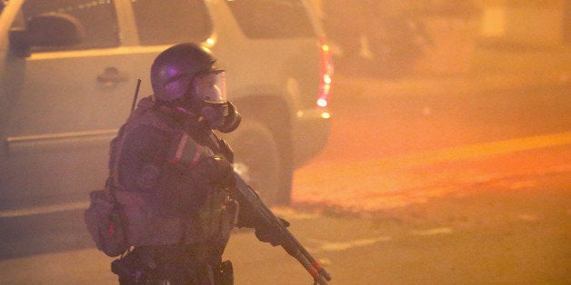 FERGUSON, MO - NOVEMBER 25: Police try to control demonstrators with tear gas during a protest on November 25, 2014 in Ferguson, Missouri. Yesterday protesting turned into rioting following the grand jury announcement to not indict officer Darren Wilson in the Michael Brown case. Brown, an 18-year-old black man, was killed by Darren Wilson, a white Ferguson police officer, on August 9. At least 12 buildings were torched and more than 50 people were arrested during the night-long rioting. (Photo by Scott Olson/Getty Images)