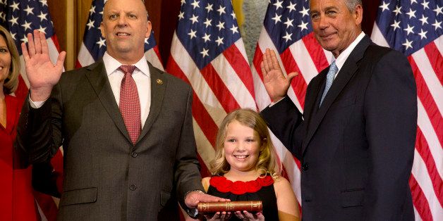 House Speaker John Boehner of Ohio administers a re-enactment of the House oath to Rep. Scott Desjarlais, R-Tenn., left, accompanied by his family, during a ceremonial re-enactment swearing-in ceremony, Tuesday, Jan. 6, 2015, in the Rayburn Room on Capitol Hill in Washington. (AP Photo/Jacquelyn Martin)