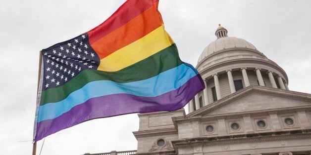 LITTLE ROCK, AR - APRIL 1: A rainbow flag flies over the crowd during a press conference by the Human Rights Campaign on the steps of the Arkansas State Capital in Little Rock following Gov. Asa Hutchinson's comments on House Bill 1228, a bill passed which prohibits state and local governments from infringing on a person's religious beliefs without a 'compelling' interest, on April 1, 2015 in Little Rock, Arkansas. Hutchinson said he won't sign the bill into law in its current form. Opponents say the bill would provide protections to businesses or individuals who refuse to serve someone based on religious beliefs. (Photo by Andrea Morales/Getty Images)