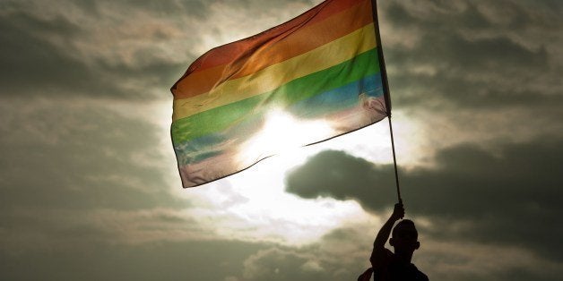 A person holds a rainbow flag during the Gay Pride Parade in San Salvador, El Salvador, on June 28, 2014. AFP PHOTO/ Jose CABEZAS (Photo credit should read JOSE CABEZAS/AFP/Getty Images)