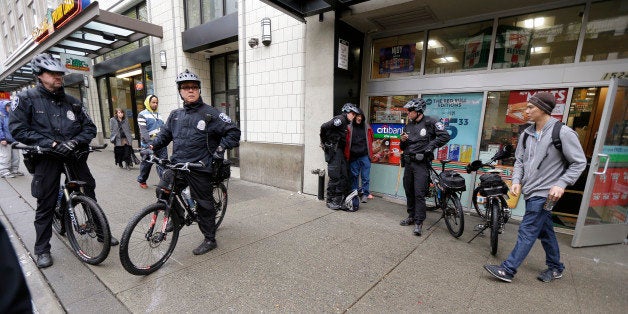 Seattle police Officers Matt Chase, left, and Tom Christenson, second from left, keep an eye on activity in downtown Seattle, Tuesday, April 7, 2015. The area they patrol has been the source of many referrals to a first-of-its-kind program called Law Enforcement Assisted Diversion, aimed at keeping low-level drug offenders and prostitutes out of jail and receiving services for housing, counseling and job training. A study released Wednesday, April 8, 2015 by the University of Washington found encouraging signs of the program's effectiveness, and other cities are hoping to start programs of their own. (AP Photo/Ted S. Warren)