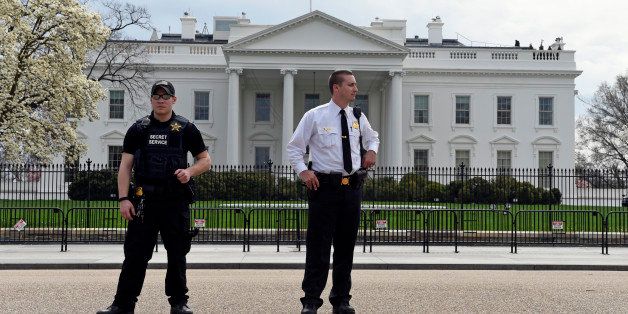 Members of the Secret Service stand on Pennsylvania Avenue outside the White House in Washington, Tuesday, April 7, 2015. The White House, State Department, and Capitol were all affected by reports of widespread power outages across Washington and its suburbs Tuesday afternoon. (AP Photo/Susan Walsh)