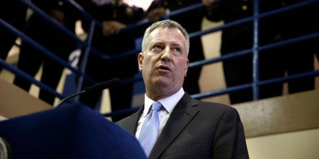 Surrounded by corrections officers, New York City Mayor Bill de Blasio holds a news conference on Rikers Island in New York, Thursday, March 12, 2015. The mayor has unveiled a comprehensive plan to curb jail violence after a visit to the problem-plagued Rikers Island jail complex. (AP Photo/Seth Wenig)