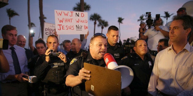 FORT LAUDERDALE, FL - NOVEMBER 12: Fort Lauderdale Police Officer, Sgt. Al Lerner asks people to move back so they can speak with Arnold Abbott, a 90-year-old chef , who was feeding homeless in violation of a recently passed city law on November 12, 2014 in Fort Lauderdale, Florida. The city said they passed the ordinance for sanitary and security reason, but Mr. Abbott continued to feed the homeless in a city park where he has twice been cited for violating the new ordinance. (Photo by Joe Raedle/Getty Images)