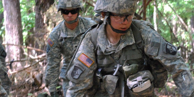 FILE - In a May 9, 2012 file photo, Capt. Sara Rodriguez, 26, of the 101st Airborne Division, carries a litter of sandbags during the Expert Field Medical Badge training at Fort Campbell, Ky. The Pentagon is lifting its ban on women serving in combat, opening hundreds of thousands of front-line positions and potentially elite commando jobs after generations of limits on their service, defense officials said Wednesday, Jan. 23, 2013. (AP Photo/Kristin M. Hall, File)