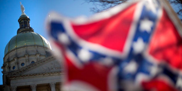 The dome of the State Capitol is seen as a protestor waves a Confederate flag during the March For Life anti-abortion rally,