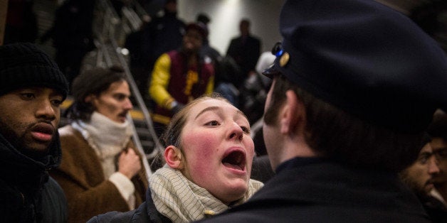 NEW YORK, NY - DECEMBER 08: Police clash with demonstraters protesting the Staten Island, New York grand jury's decision not to indict a police officer involved in the chokehold death of Eric Garner in July inside the Barclays Center subway station after a Brooklyn Nets game on December 8, 2014 in New York City. The royal couple, Prince William and Catherine, Duchess of Cambridge are on an official three-day visit to New York including watching a Brooklyn Nets game. (Photo by Andrew Burton/Getty Images)