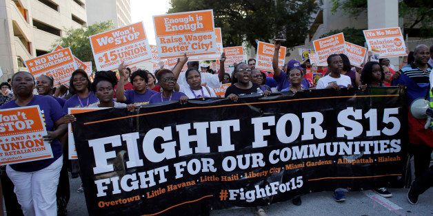 Protestors march in support of raising the minimum wage to $15 an hour as part of an expanding national movement known as Fight for 15, Wednesday, April 15, 2015, in Miami. The event was part of a national protest day to coincide with the April 15 deadline for filing income taxes. (AP Photo/Lynne Sladky)