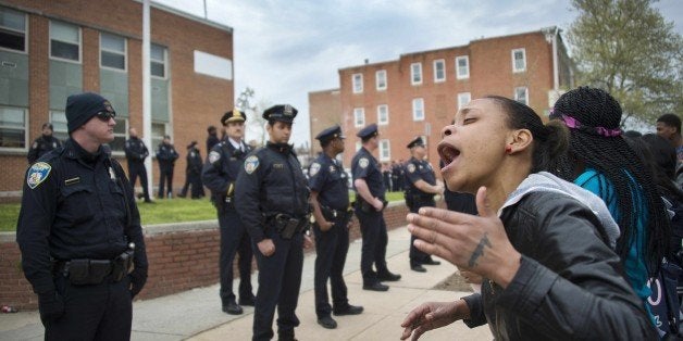 Demonstrators yell at police as they protest the death Freddie Gray, an African American man who died of spinal cord injuries