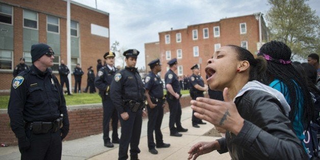 Demonstrators yell at police as they protest the death Freddie Gray, an African American man who died of spinal cord injuries in police custody, in front of the Baltimore Police Department Western District in Baltimore, Maryland, April 23, 2015. Several Baltimore police officers have been suspended after an African American man died of spinal cord injuries in police custody, police said, pledging to thoroughly investigate the incident. AFP PHOTO/JIM WATSON (Photo credit should read JIM WATSON/AFP/Getty Images)