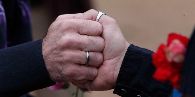 Steve Davis and James Farless hold hands as they are married by Rev. Marge Ragona, Metropolitan Community Church, in Linn Park, at the Jefferson County courthouse, Monday, Feb. 9, 2015, in Birmingham, Ala. A federal judge's order overturning the state's ban on gay marriage goes into effect on Monday, making Alabama the 37th state to allow gays and lesbians to wed. (AP Photo/Hal Yeager)