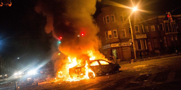 BALTIMORE, MD - APRIL 27: Two cars burn in the middle of an intersection at New Shiloh Baptist Church on April 27, 2015 in Baltimore, Maryland. Riots have erupted in Baltimore following the funeral service for Freddie Gray, who died last week while in Baltimore Police custody. (Photo by Andrew Burton/Getty Images)