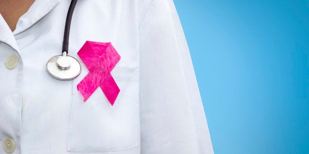 healthcare and medicine concept - female doctor with pink breast cancer awareness ribbon