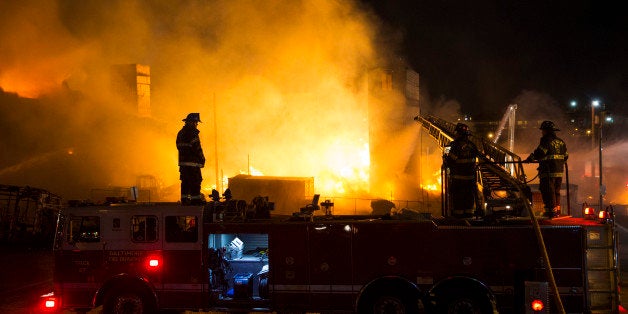 Firefighters battle a blaze, Monday, April 27, 2015, after rioters plunged part of Baltimore into chaos, torching a pharmacy,