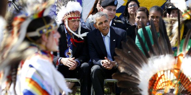 In this June 13, 2014 file photo President Barack Obama and Chairman of the Standing Rock Sioux Tribe David Archambault II, left, watch dancers during a visit to the Standing Rock Indian Reservation in Cannon Ball, N.D. Obama on Wednesday, Dec. 3, 2014 announced an initiative to improve conditions and opportunities for American Indian youth, more than one-third of whom live in poverty. (AP Photo/Charles Rex Arbogast, File)