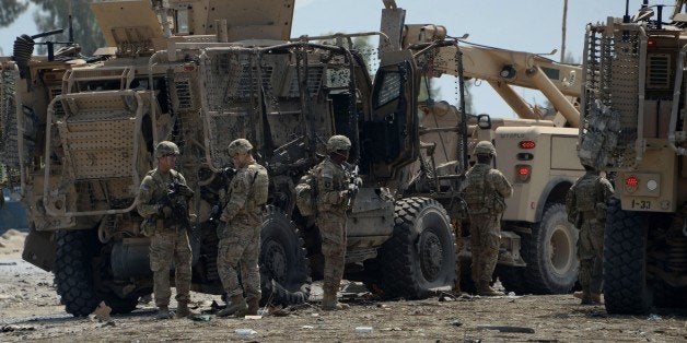 US soldiers inspect the scene of a suicide bomb attack near the airport in the Afghan city of Jalalabad on April 10, 2015. A