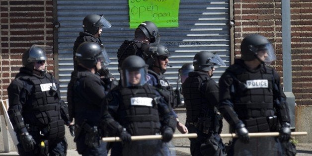 Policemen take a position outside a store at the Western District in Baltimore, Maryland on April 29, 2015. Riot police in th