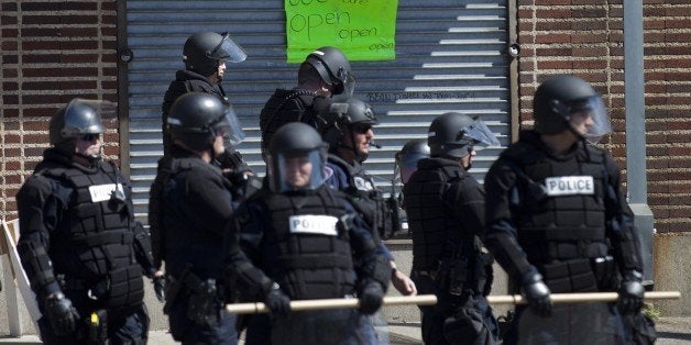 Policemen take a position outside a store at the Western District in Baltimore, Maryland on April 29, 2015. Riot police in the US city of Baltimore enforced a curfew into the early hours of Wednesday and called it a success, emptying streets scarred by a spasm of rioting and looting. AFP PHOTO/ANDREW CABALLERO-REYNOLDS (Photo credit should read Andrew Caballero-Reynolds/AFP/Getty Images)