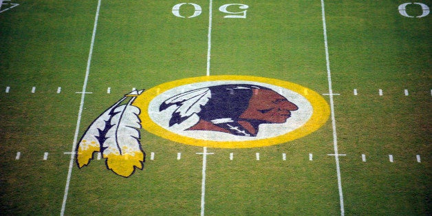 FILE - In this Aug. 28, 2009 file photo, the Washington Redskins logo is shown on the field before the start of a preseason NFL football game against the New England Patriots in Landover, Md. A long-running dispute over the Washington Redskinsâ team name will likely go another quarter. A Virginia judge suggested Friday that a group of Native Americans offended by the name are properly being sued by the football team. (AP Photo/Nick Wass, File)