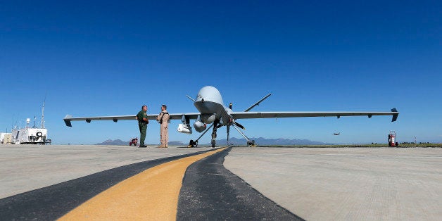 Lothar Eckardt, right, executive director of National Air Security Operations at U.S. Customs and Border Protection, speaks with a Customs and Border Patrol agent prior to a drone aircraft flight, Wednesday, Sept 24, 2014 at Ft. Huachuca in Sierra Vista, Ariz. The U.S. government now patrols nearly half the Mexican border by drones alone in a largely unheralded shift to control desolate stretches where there are no agents, camera towers, ground sensors or fences, and it plans to expand the strategy to the Canadian border. It represents a significant departure from a decades-old approach that emphasizes boots on the ground and fences. (AP Photo/Matt York)